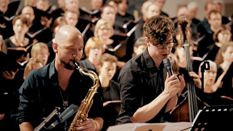 Foto des Münchner Motettenchors auf dem im Vordergrund Jazzmusiker zu sehen sind