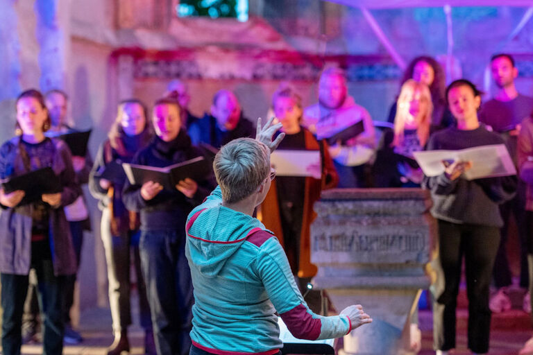 Ein Chor tritt in einer Kirchenruine auf