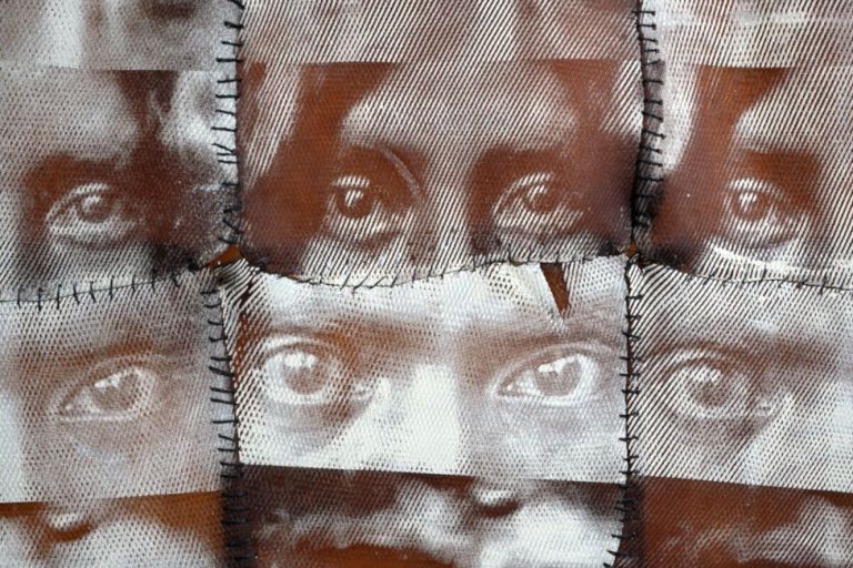Kunstwerk aus zusammengenähten Stoffstücken, die Teile von Gesichtern zeigen