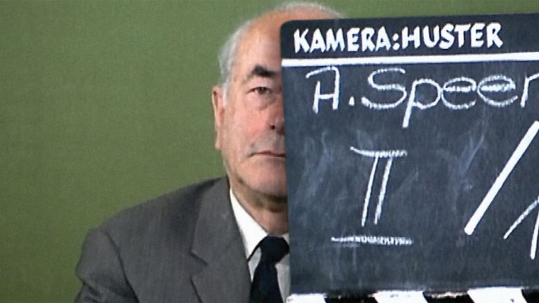 Foto von Albert Speer, dessen Gesicht zur Hälfte von einer Filmklappe verdeckt wird