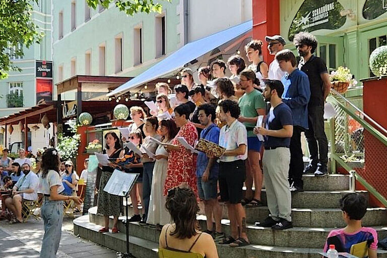 Foto des Chors bei einem sommerlichen Konzert auf einer Freitreppe