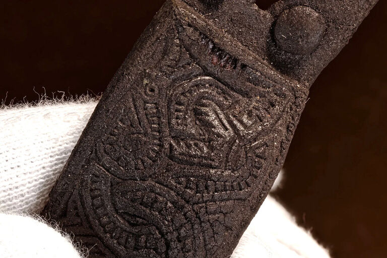 Nahaufnahme eins Stücks Holz oder Leder, in das ein Muster eingraviert wurde