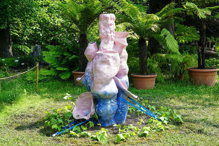 Skulptur aus ungleichmäßig geformten Tongefäßen in einem Garten