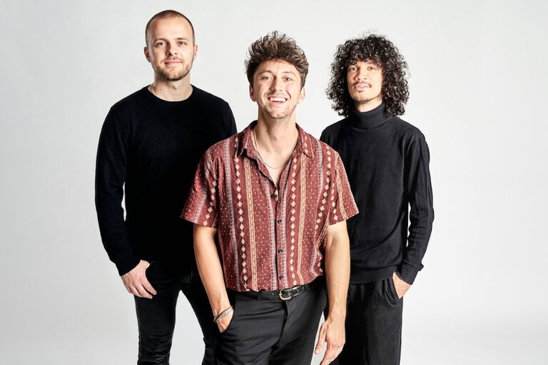 Gruppenfoto der der freundlich blickenden Musik vor grauem Hintergrund