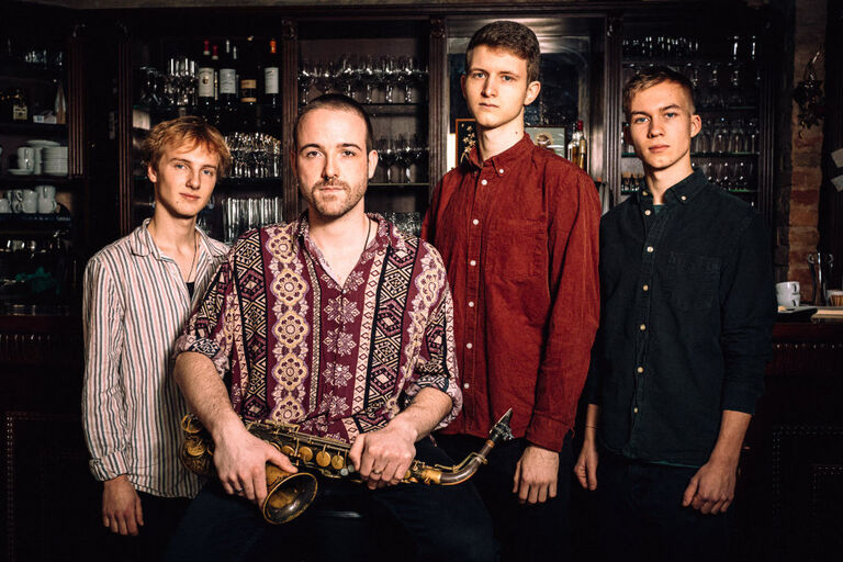 Gruppenfoto des Quartetts in einer Bar
