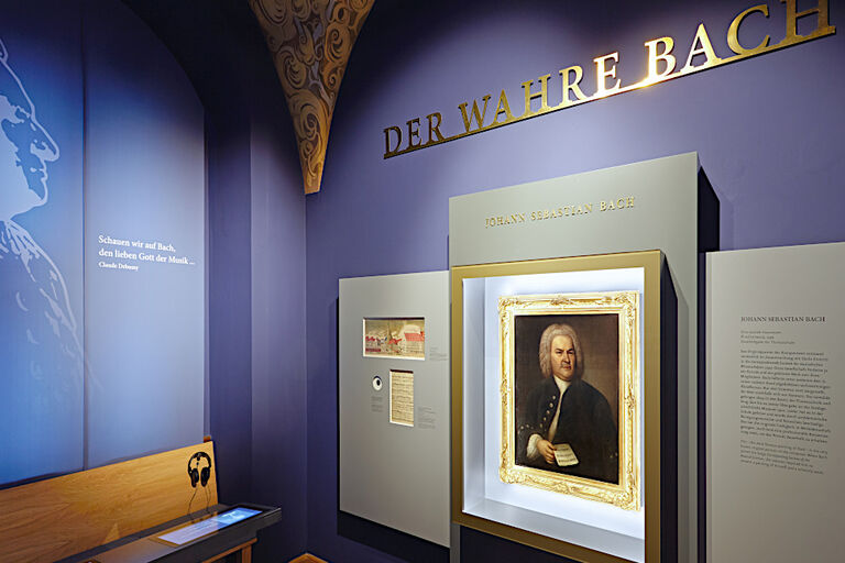 Ausstellungsraum mit einem Gemälde von Bach, einer Hörstation und Informationstafeln
