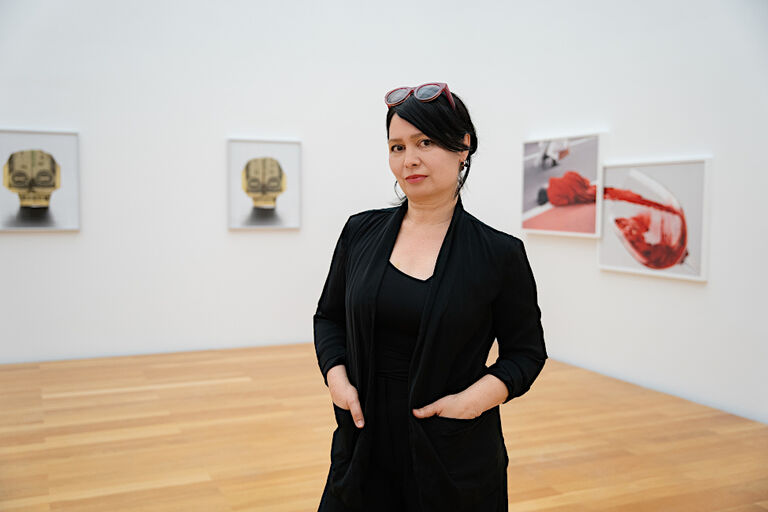 Die Fotografin steht in der Ausstellung vor ihren Bilden