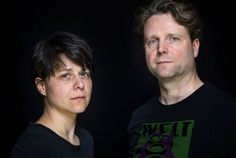 Nahaufnahme einer Schauspielerin und eines Schauspielers vor schwarzem Hintergrund