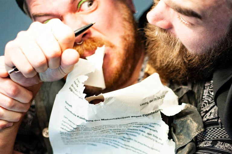 Zwei Männer kämpfen um einen Brief, der eine Wohnungskündigung enthält.