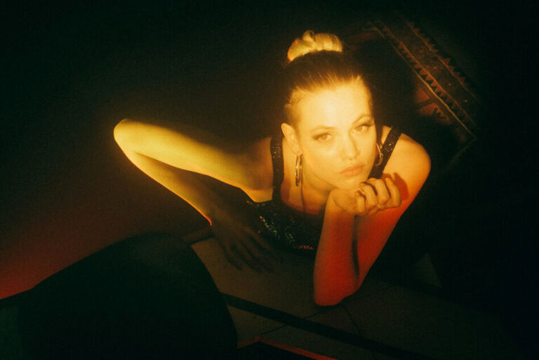 Foto der Sängerin, die in einem dunklen Raum sparsam angeleutet wird