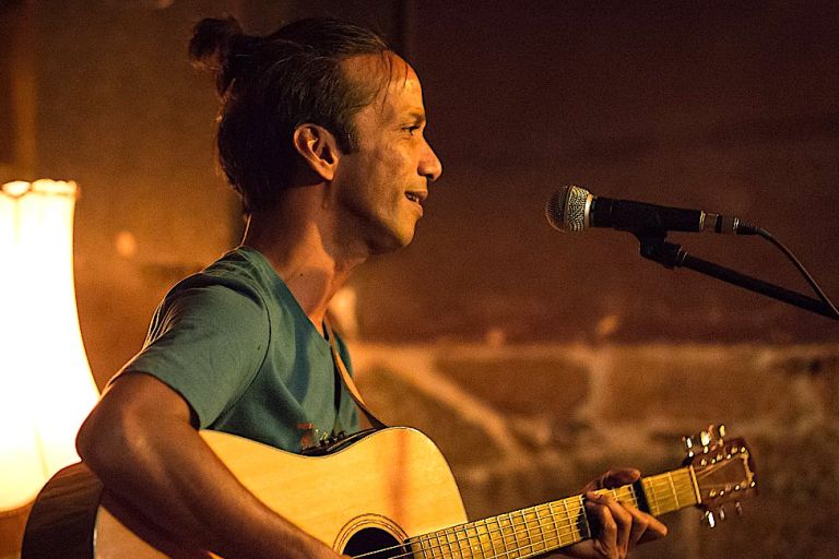 Nahaufnahme des Musikers bei einem Konzert mit seiner Gitarre