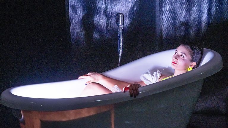 Eine schöne junge Frau liegt mit nachdenklichem Gesicht in einer Badewanne.
