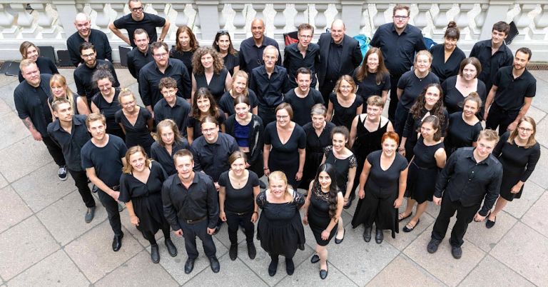 Gruppenfoto der Sängerinnen und Sänger auf einer Terasse von oben fotografiert