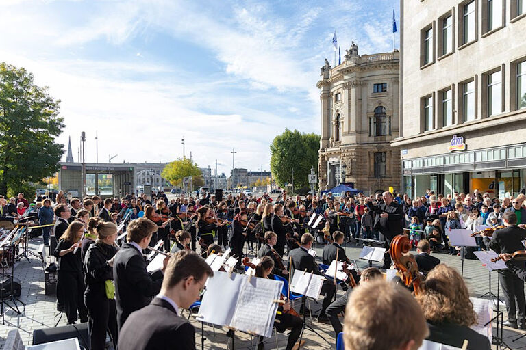 Klassisches Konzert in einer Fußgängerzone, bei dem viele Menschen zuhören