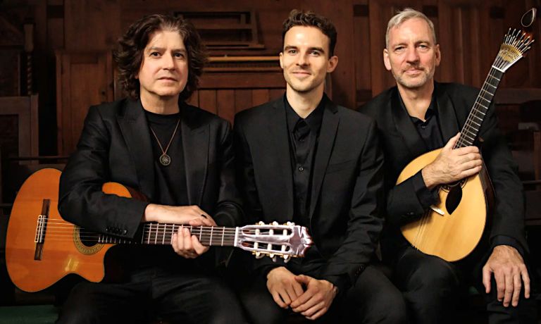 Gruppenfoto des Trios mit seinen Instrumenten und in schwarzen Anzügen