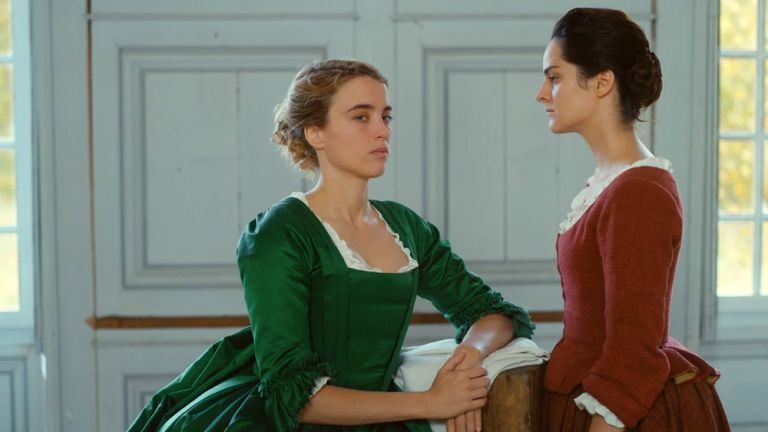 Zwei Frauen stehen sich in historischen Kleidern gegenüber. Während die eine vor sich hin schaut, wird sie von der anderen intensiv angesehen.