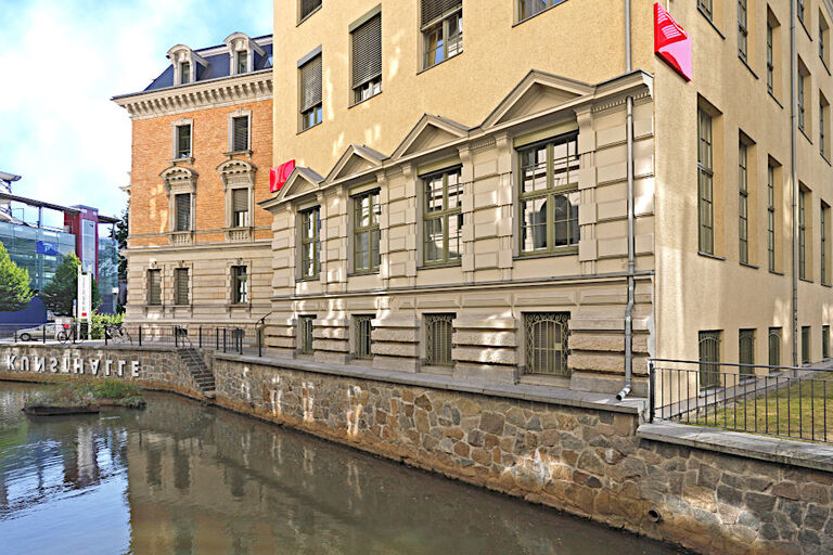 Das Gebäude der Kunsthalle spiegelt sich in einem Wasserlauf.