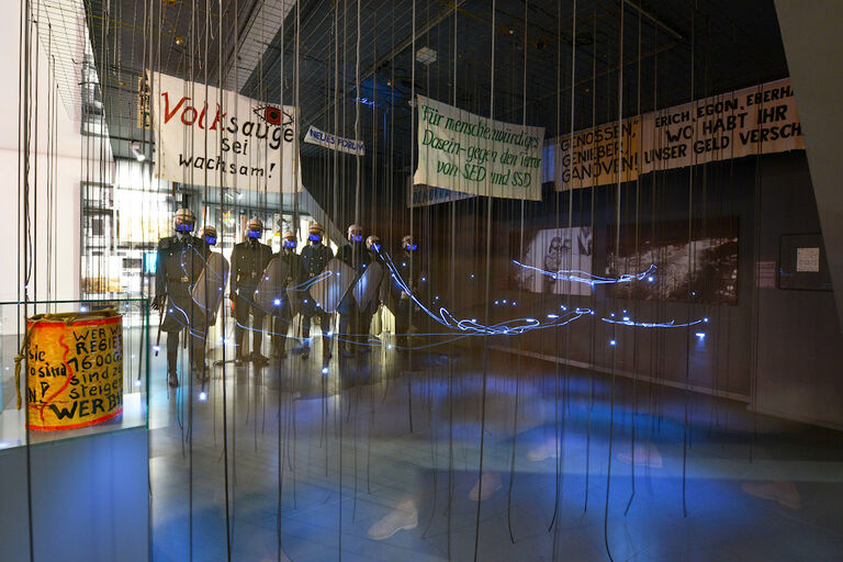 Ein Raum voller Transparente und einer Gruppe von lebensgroßen Puppen in Polizeiuniform