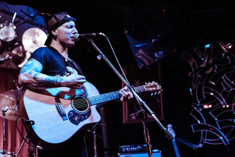 Foto des Musikers mit Gitarre bei einem Konzert