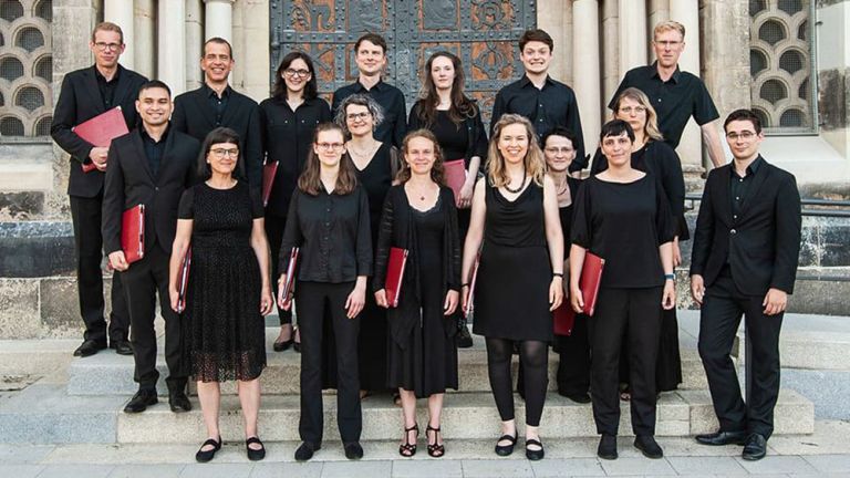Gruppenfoto des Ensemble TonART in schwarzer Kleidung vor einem Kirchenportal
