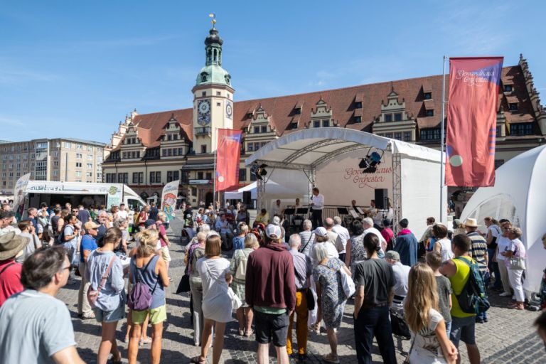 Viele Menschen stehen vor einer Bühne auf dem Markt, auf der gerade der Gewandhaustag eröffnet wird.
