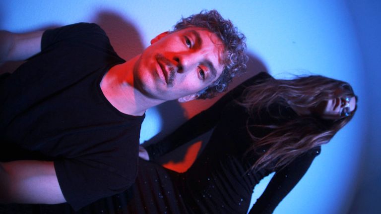 Foto des Duos, auf dem die Sängerin und und der Keyboarder mit rotem und blauen Licht angestrahlt werden