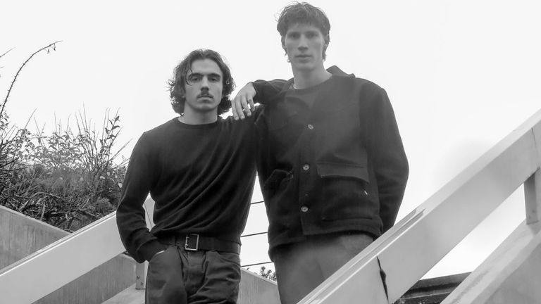 Foto des ernst blickenden Duos auf einer Treppe im Freien