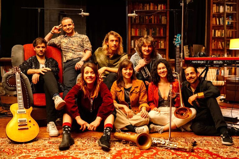 Der Band in einem Studio, das eingerichtet ist wie ein gemtliches Wohnzimmer