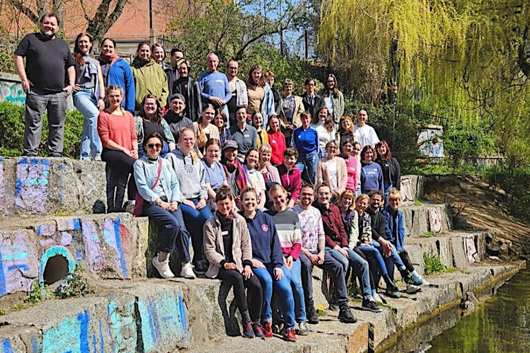 Gruppenfoto des Chors auf einer großen Steintreppe am Wasser
