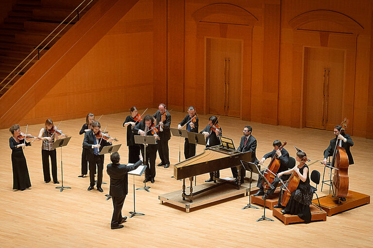 Foto des Orchesters bei einem Auftritt in einem großen und hohen Saal