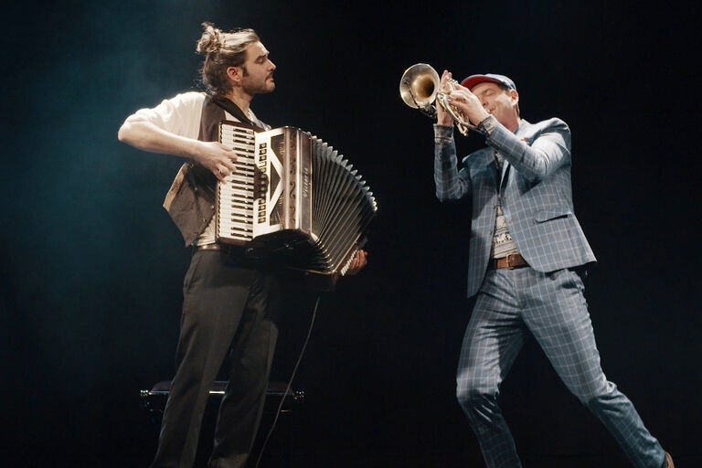 Foto der beiden Musiker mit ihren Instrumenten bei einem Auftritt