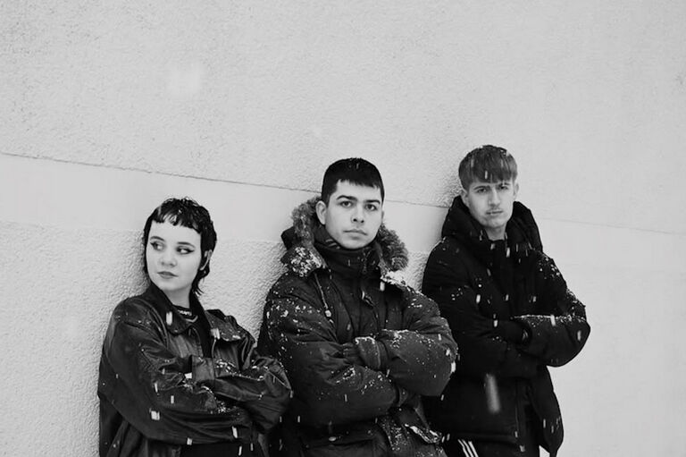 Gruppenfoto des Trios in Winterjacken voller Schnee