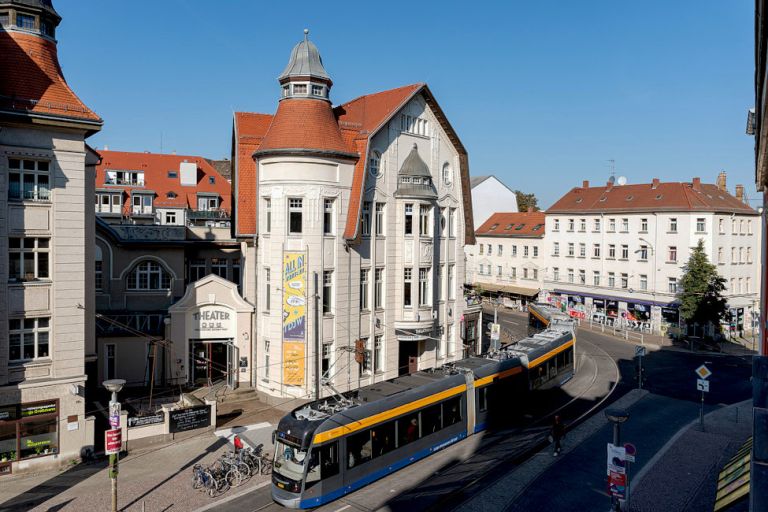 Das helle Gebäude des Theaters an einem sonnigen Tag vor blauem Himmel