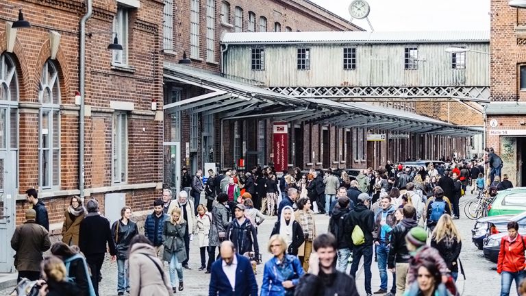 Viele Menschen sind auf dem Gekände der historischen Baumwollspinnerei unterwegs.