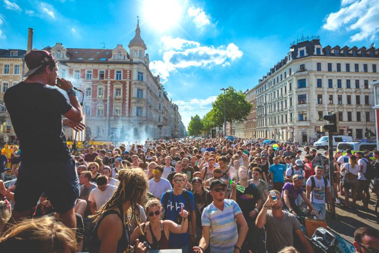 Eine unübersehbare Menschenmenge zieht durch eine breite Straße von Leipzig.