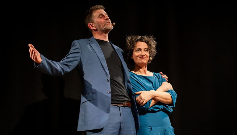 Das Duo steht bei einem Auftritt nebeneinander auf der Bühne.