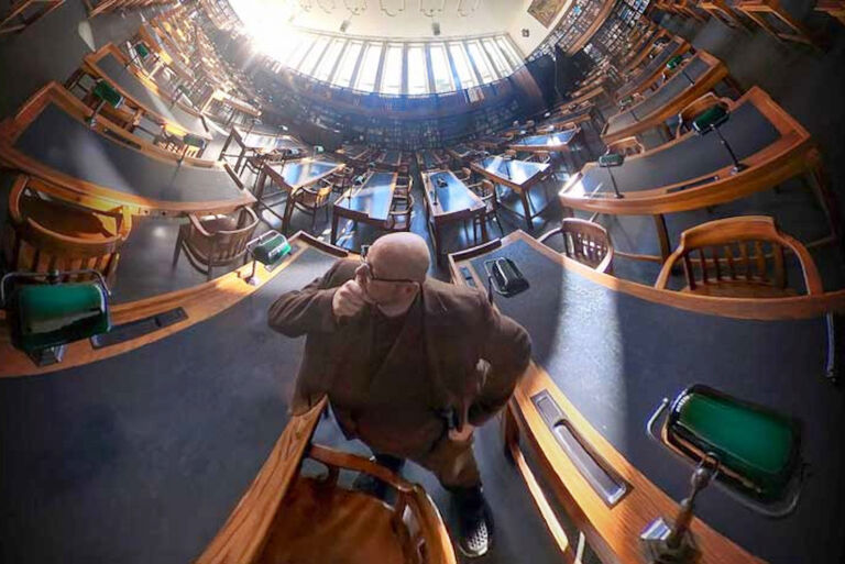 Christians von Aster steht in einem leeren Lesesaal der Deutschen Nationalbibliothek.