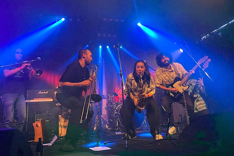 Die Band hat bei einem Auftritt auf einer kleinen Bühne viel Spaß.