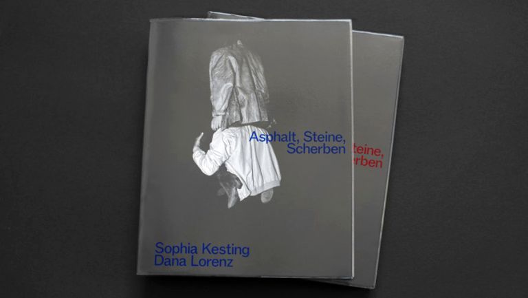 Die Vorderseite des Buches zeigt ein Foto von zwei Personen von hinten, von denen eine die andere gerade auf die Schultern nimmt.