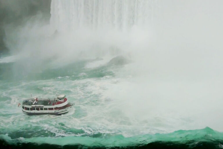Ein Touristenbot direkt an den Niagara Wasserfällen wirk dort wie ein winziges Spielzeug