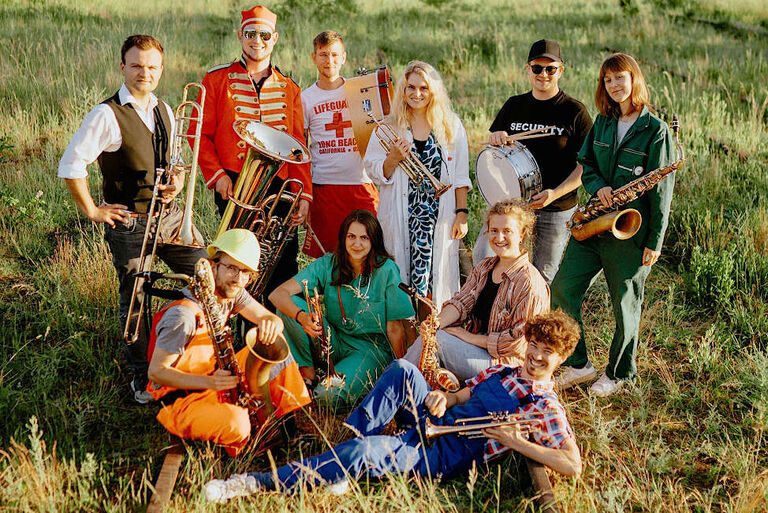 Gruppenbild der Band in verschiedenen Kostümen und mit ihren Instrumenten