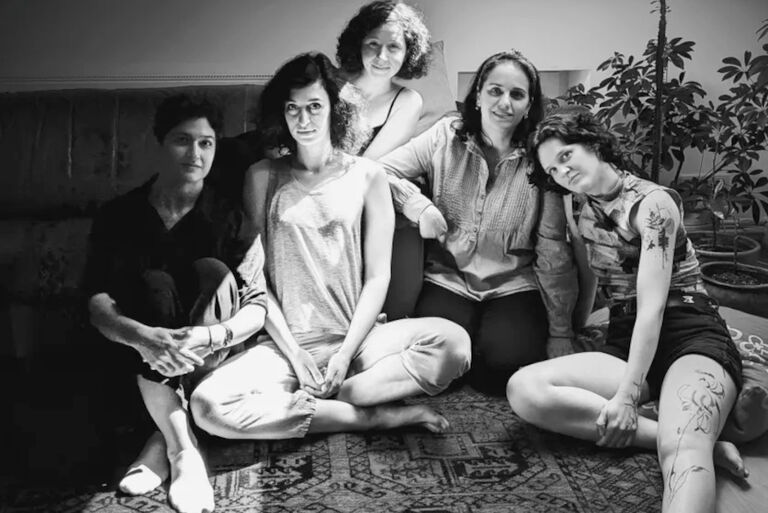 Schwarz-Weiß-Gruppenfoto der fünf Musikerinnen auf einem Teppich