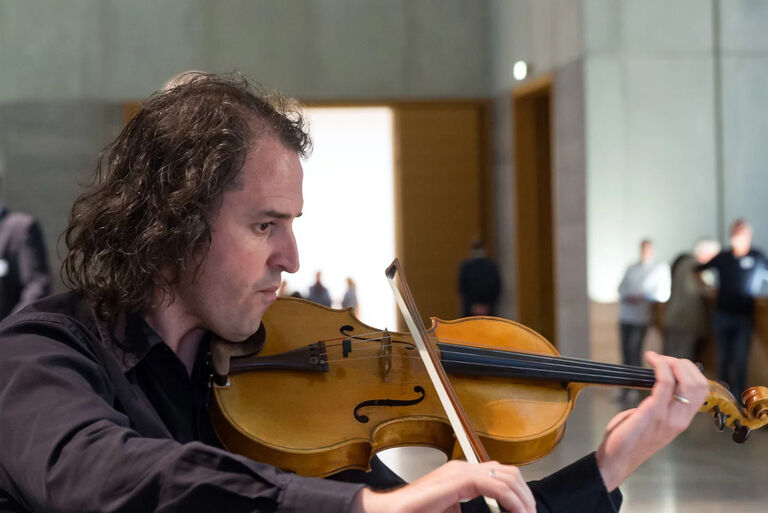 Ein Geiger spielt vor Publikum in einem Lichthof des Museums für Bildende Künste in Leipzig.