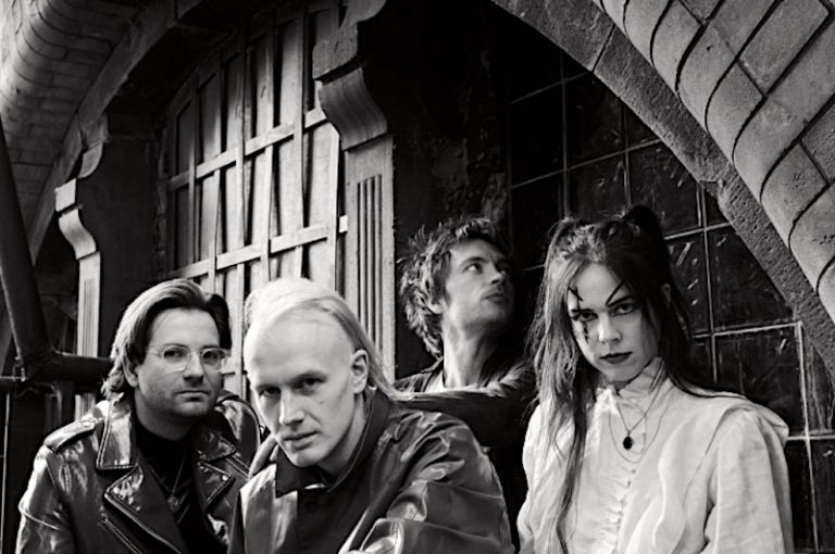 Foto der Band vor einem historischen Tor