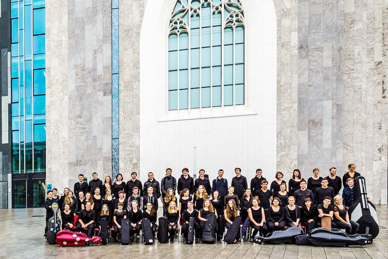 Gruppenfoto des Orchesters vor der Fassade es Paulinums in Leipzig