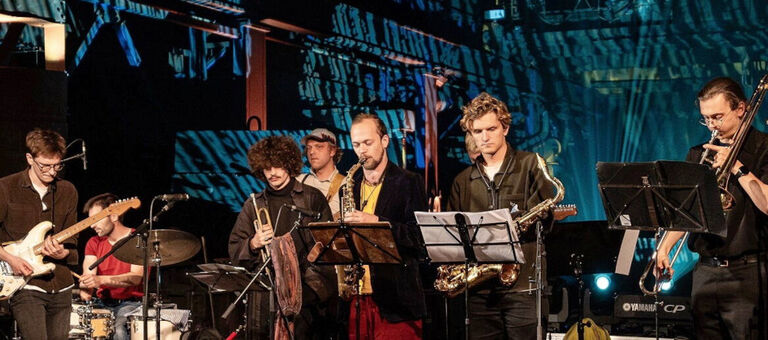Sieben Musiker bei einem Konzert in einem Klub.