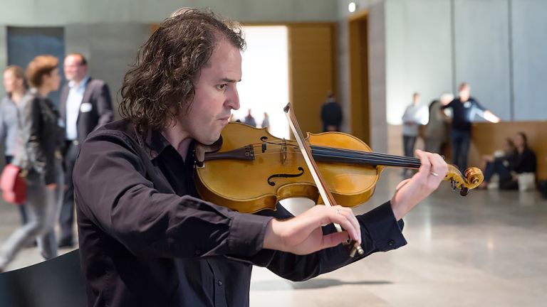 Ein Geiger spielt vor Publikum in einem Lichthof des Museums für Bildende Künste in Leipzig.
