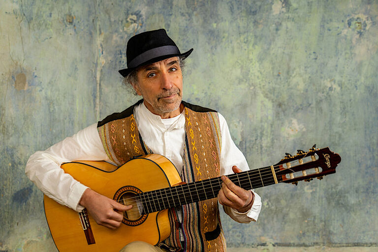 Porträtfoto des freundlich blickenden Musikers mit seiner Gitarre