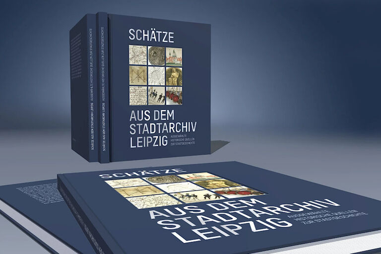 Fünf Exemplare des Buches mit bleuem Einband und mehreren Bildern auf dem titel stehen und liegen auf einem Tisch