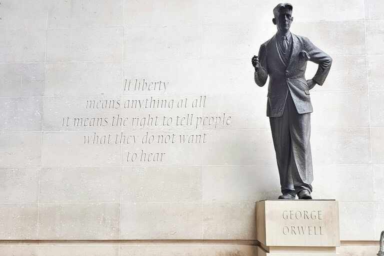 Die Statue von George Orwell steht vor einer Wand mit der Inschrift "If liberty means anything at all it means the right to tell people what they do not want to hear.".